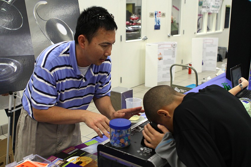 Aaron Strand from Benz Research and Development explains the UV protection display to Damar Seadrow on Friday, Feb. 25 at Southside Elementary's Science Night.