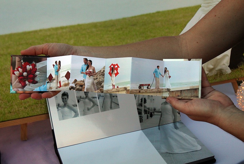 Kollene Carisson of Blonde Cow Photography shows off an accordian book of wedding photos on Saturday, Feb. 26 at St. Armands Circle's Weddings in Paradise Circle of Love event.