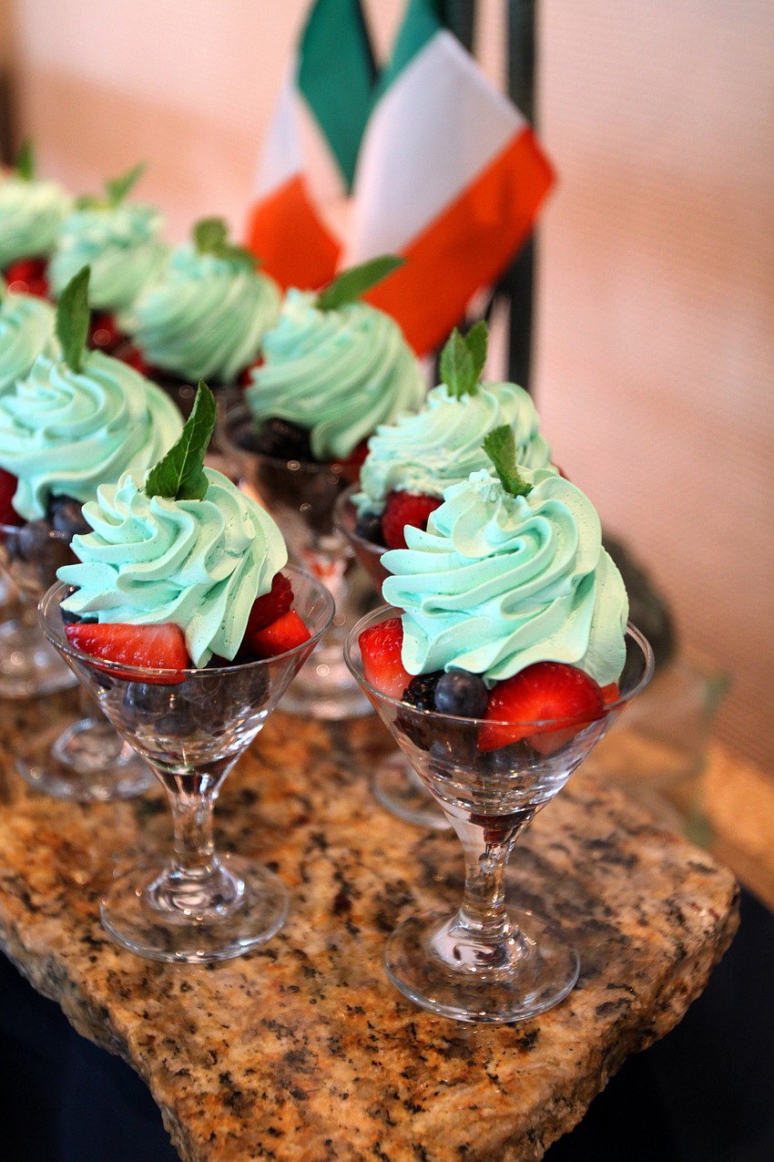 Fruit decorated with green whip cream and a leaf of mint.