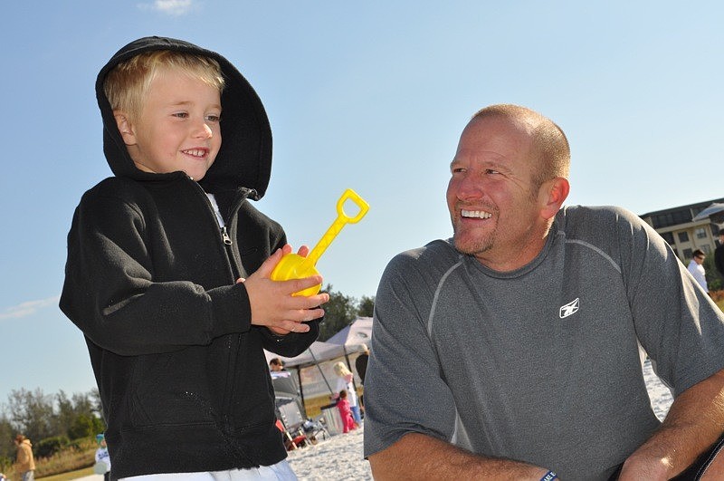 Nic Penker, 5, and his dad, Mike, talked about cars with one a sand sculptor, who was on site.