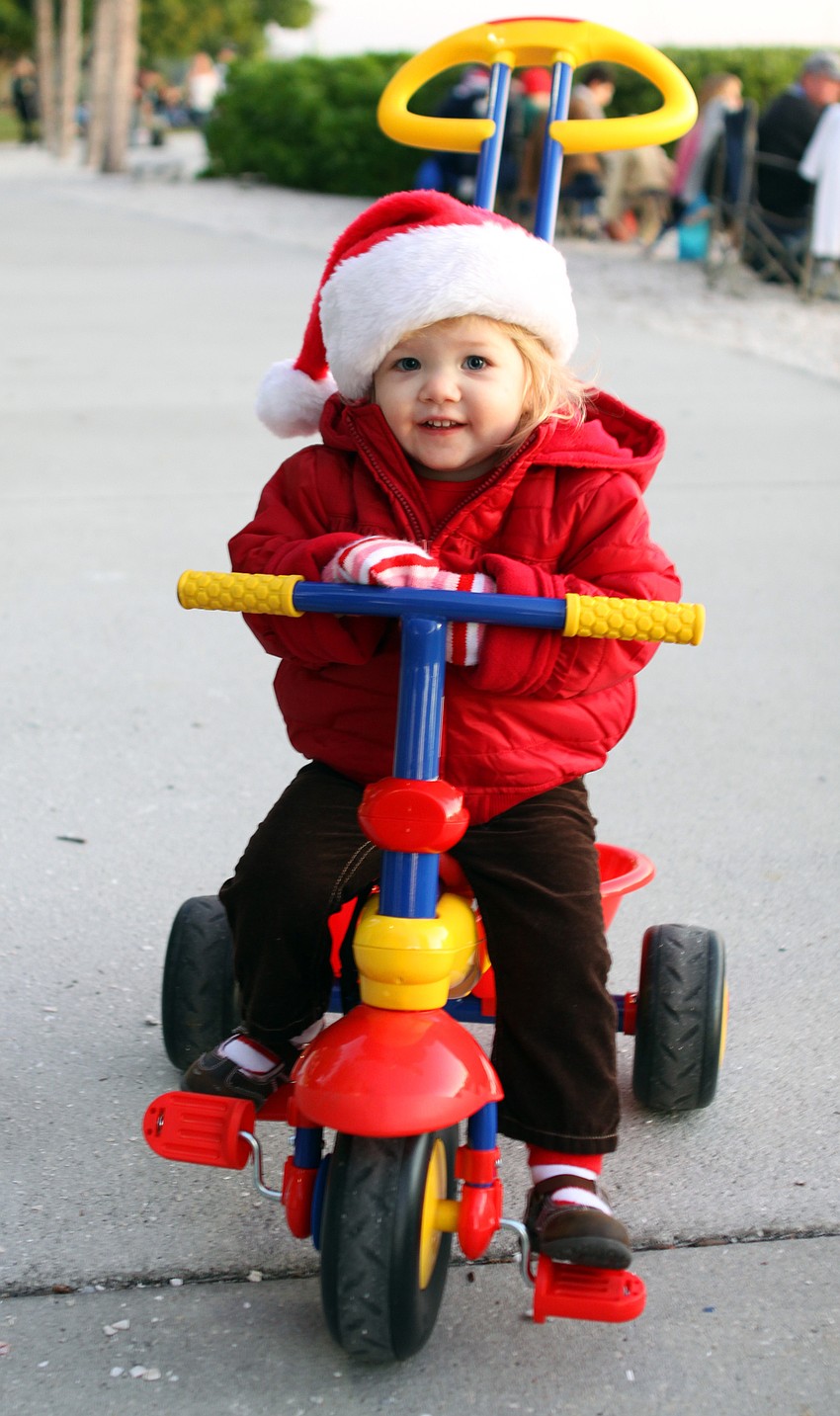 Addison Hartley rides around Bayfront Park while wearing a Santa hat and holiday gloves prior to the boat parade on Saturday, Dec. 11.