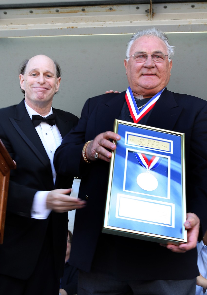 Chuck Sidlow and Jean â€œTarzanâ€ Zerbini show off Zerbiniâ€™s framed award for being inducted into the Circus Ring of Fame.