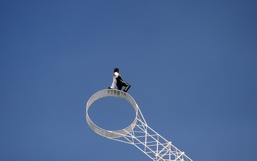 Joseph Bauer poses blind-folded while riding the â€œWheel of Destinyâ€ on Tuesday on top of the Watergate Condominium.