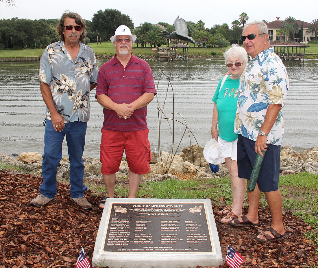 Wes Cackler, Frank Gargiulo, Arlene Volpe and Tom Gargiulo stand by a plaque naming the remembered soldiers and one of two new bronze Blue Heron Sculptures at Waterfront Park in Palm Coast.