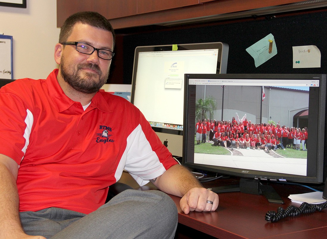 Nathan Lovelette, principal at Buddy Taylor Middle School, has a photo of his staff on his computer. Photo Jacque Estes