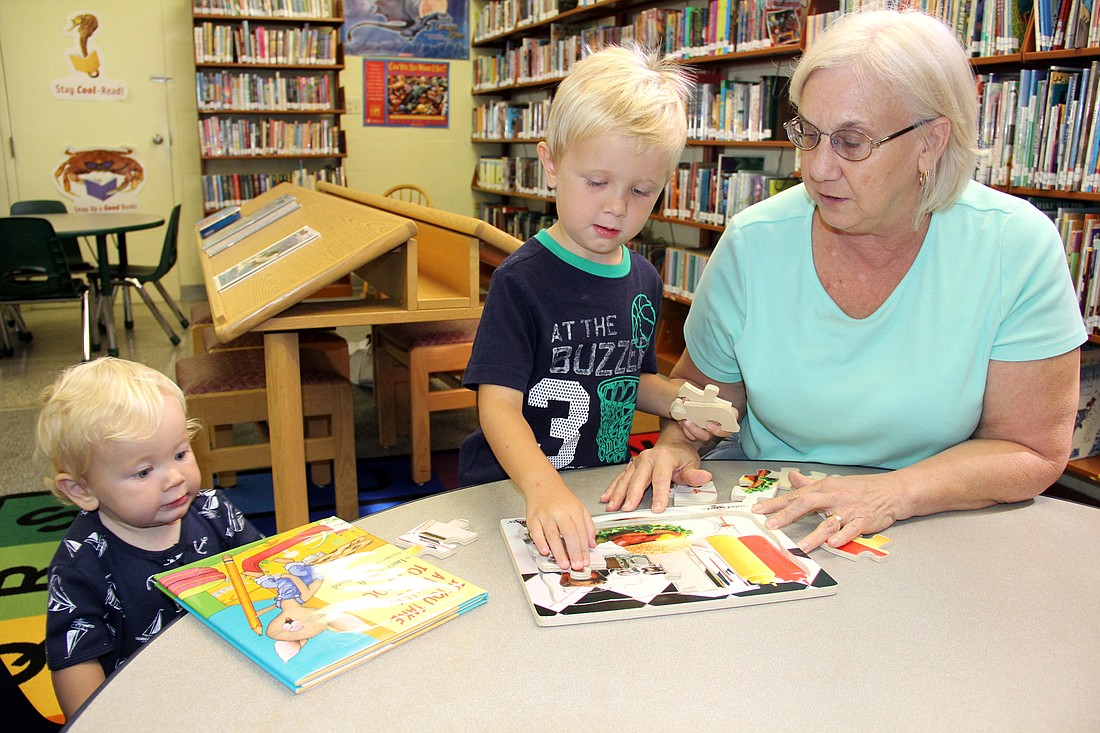 Linda Crego helps Connor and Cole Barton at the Bunnell Branch of the Flagler County Public Library. Photo Jacque Estes