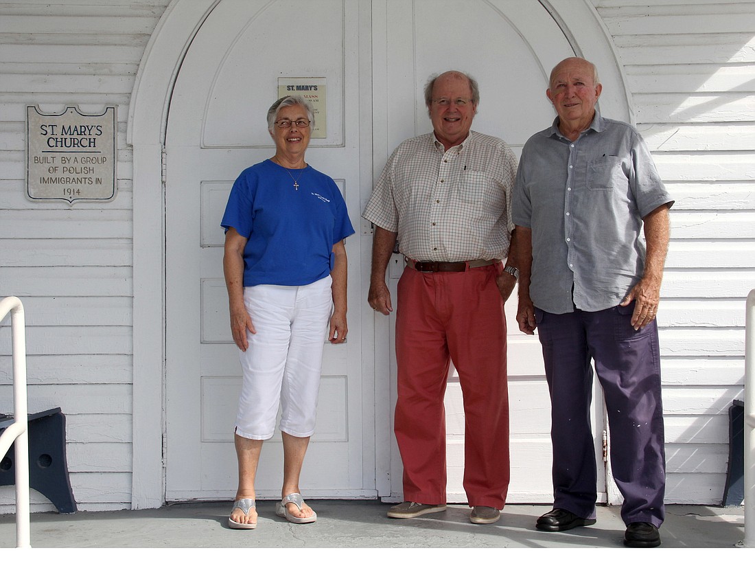 Shirley Anderson, Roger Losekamp, and Gerard Slovak, stand in the entry way of the first St. Mary's Church in Korona. Photo Jacque Estes
