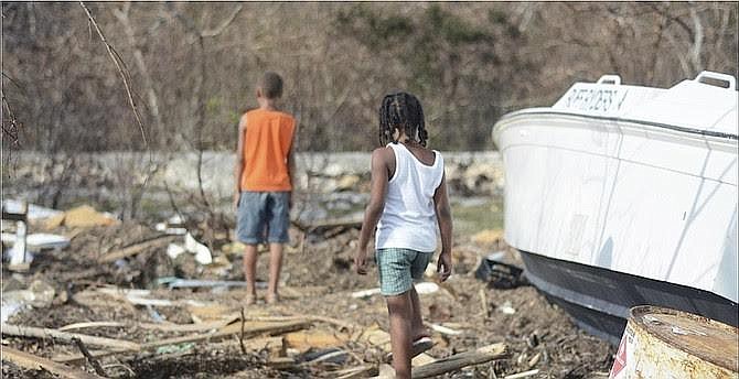 Two children in Long Island, Bahamas, walk through the debris left by Hurricane Joaquin. Courtesy photo