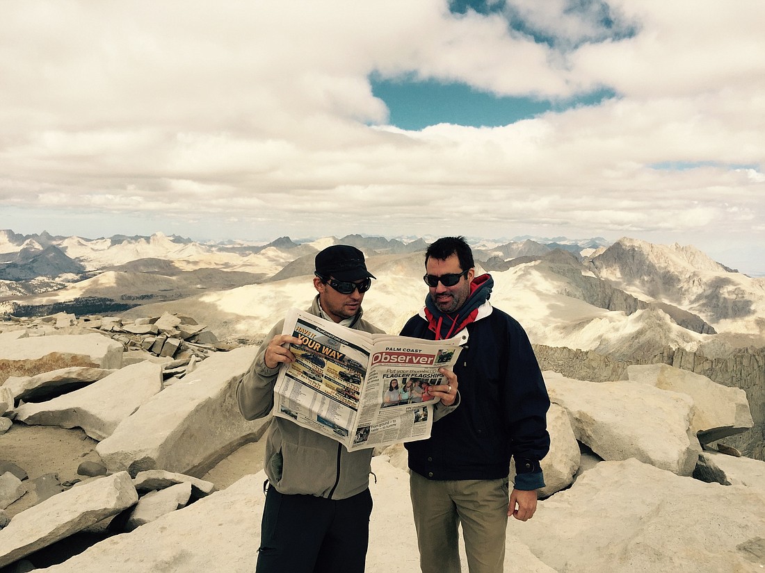 After a two-day hike up Mt. Whitney, Chris Moden and Sean Sweeney, take a break from the "humdrum" scenery to read their Palm Coast Observer. Courtesy photo