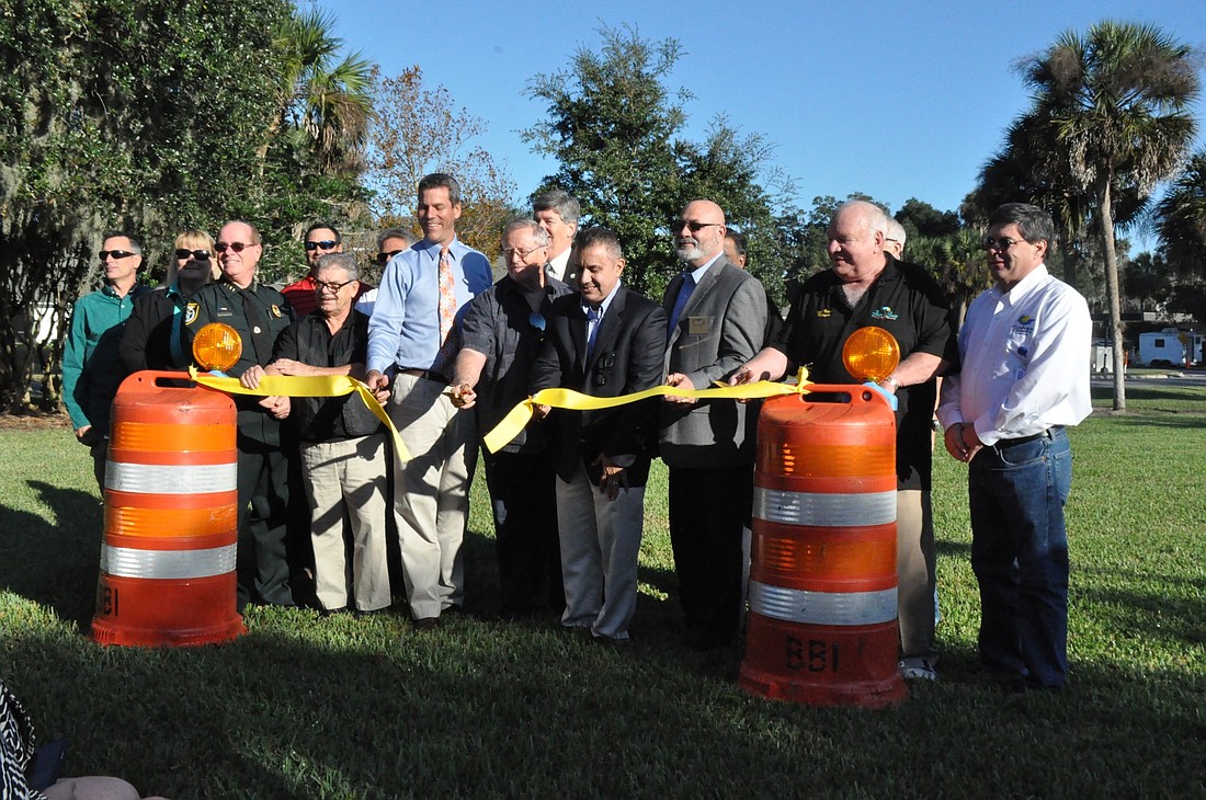 City and county officials and staff from construction management company Hill International cut a ribbon to mark the completion of the Palm Coast Parkway six-laning project. (Photo by Jonathan Simmons.)