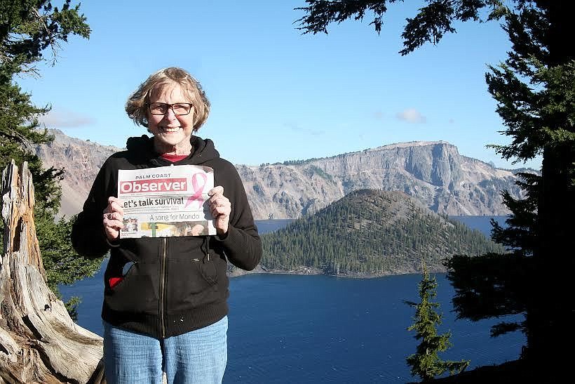 Mindy Beinart holds tight to her Palm Coast Observer at Crater Lake, Oregon. Courtesy photo