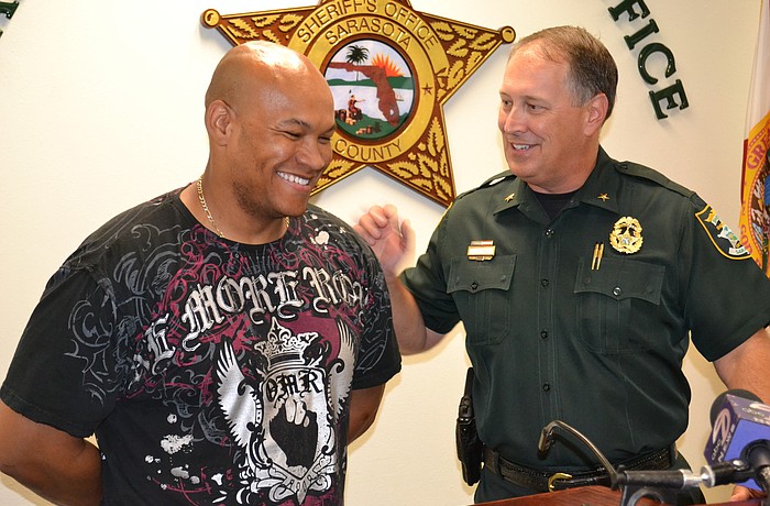 Sheriff Tom Knight presents Army Staff Sgt. Eddie Peoples with a commendation award for his bravery in capturing a bank robbery suspect.