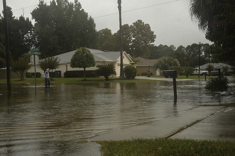 Jeffrey Qualls wades through the flash flooding towards his house on Westgrill in Palm Coast. (Photo by Anastasia Pagello)