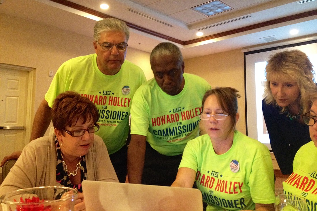 Howard Holley and supporters used a laptop to watch election results come online. (Photo by Shanna Fortier.)