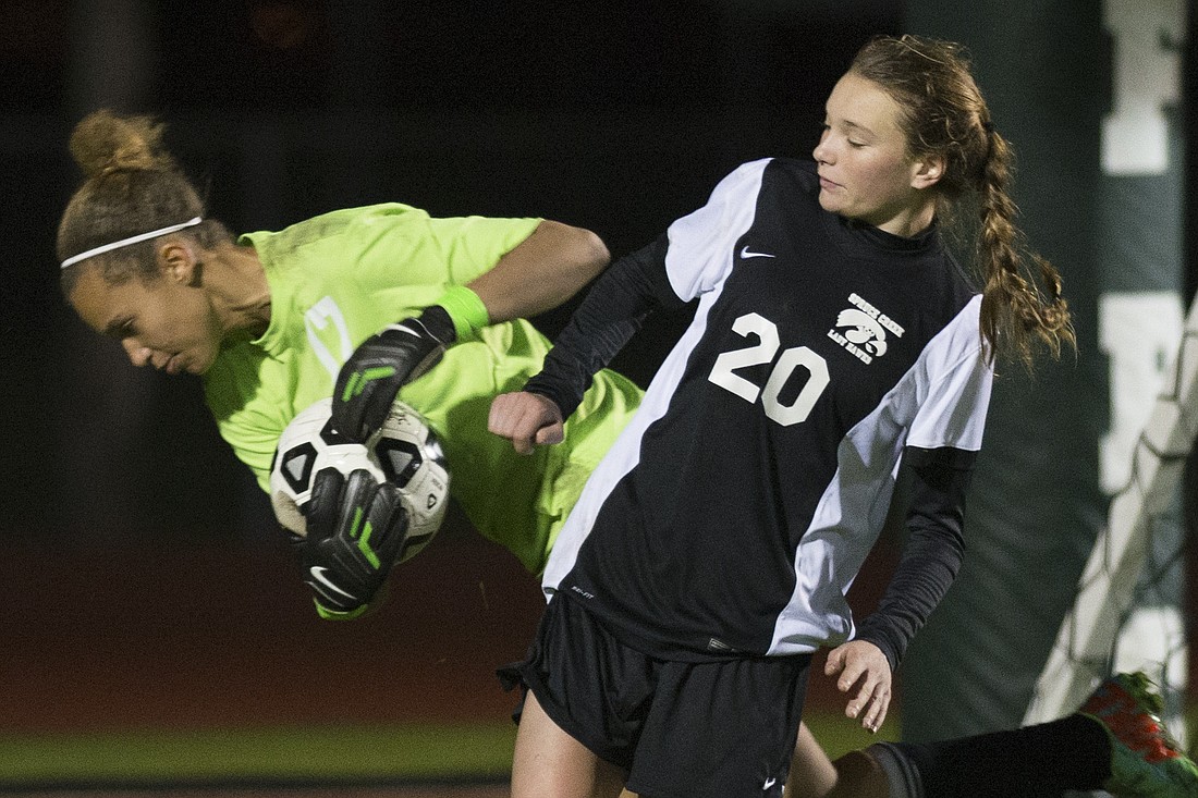 Leah Leach makes a diving save to help the Bulldogs secure a third straight district championship. (Photo by Steven Libby)