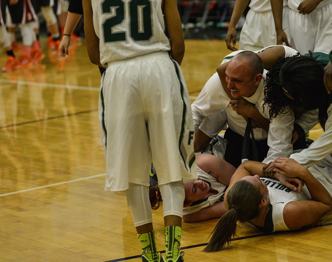 Coach Javier Bevacqua and players fall to the ground hugging, after being crowned regional champs.