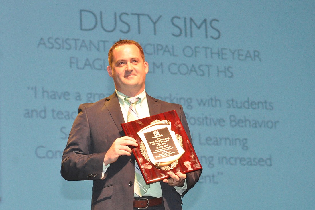 Dusty Sims holds his district Assistant Principal of the Year Award at a ceremony Jan. 15. (File photo by Jonathan Simmons.)