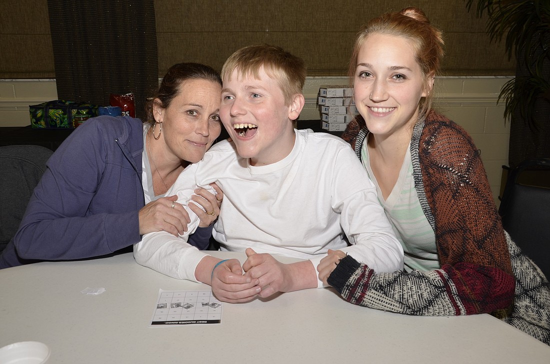 Best Buddies member David McMillan is surrounded by love and support by his mother, Sharon, and Mikki Madden.
