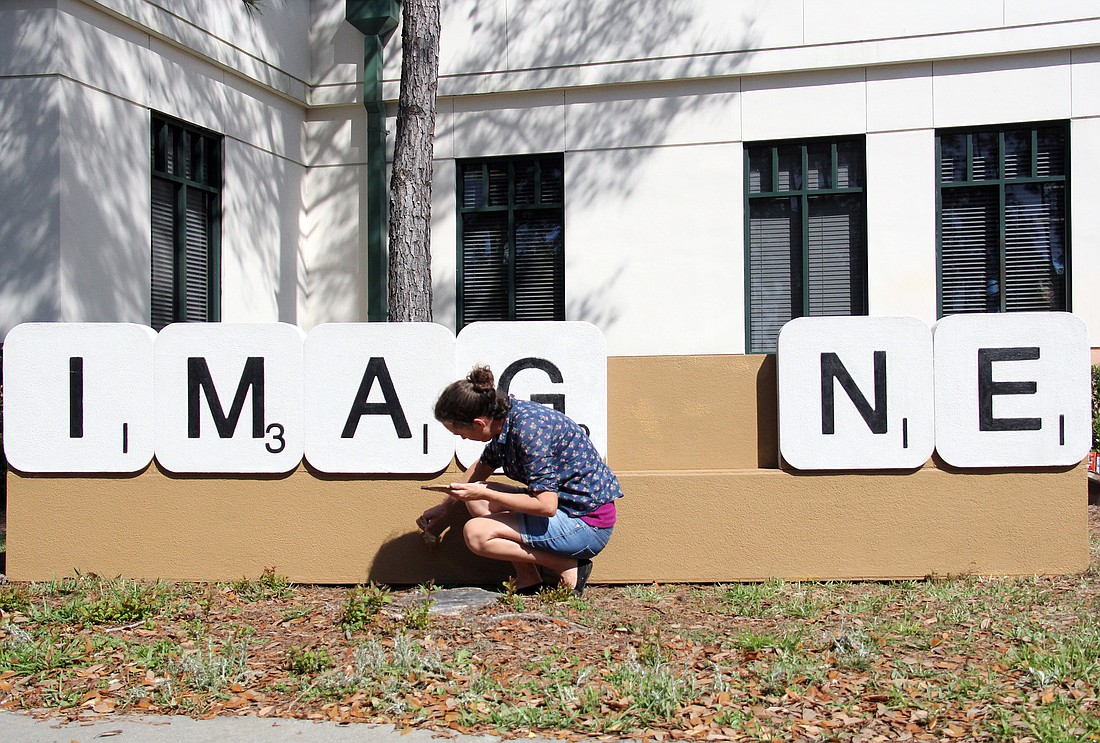 Australian artist Emma Anna puts the finishing touches on her public art instillation Ã¢â‚¬Å“IMAG_NEÃ¢â‚¬Â at the Flagler County Public Library.