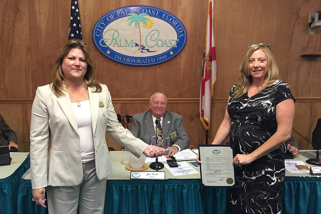 Palm Coast Urban Forester Carol Mini, right, presents the Tree City USA 10-Year Award to Palm Coast Council Member Heidi Shipley and Mayor Jon Netts. (Courtesy photo.)