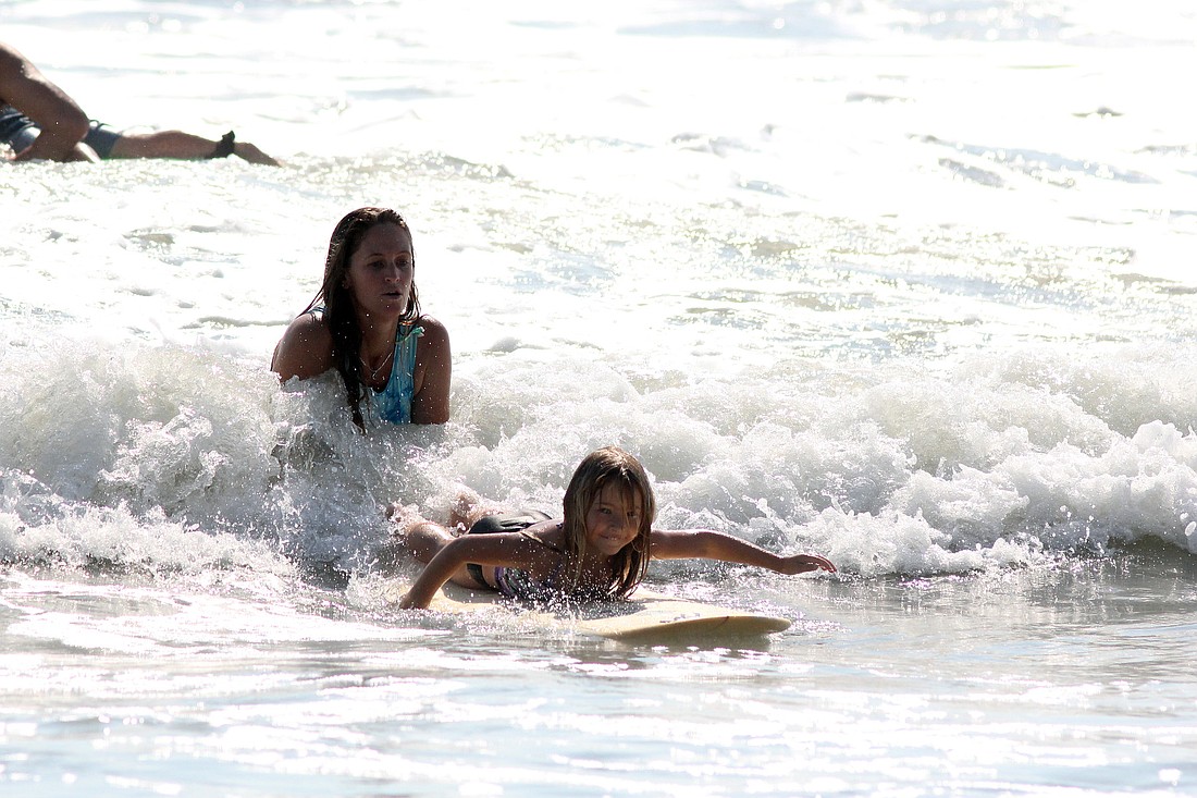 Carla Cline pushes Penelope McDonald into a wave during the Minnows division.