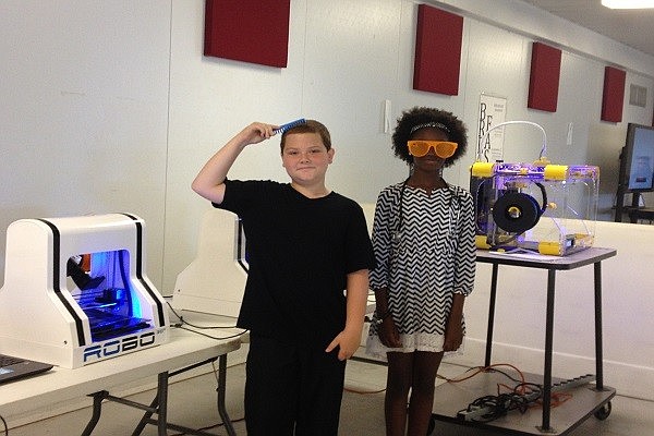 Jayden Diaz and Destiny Simpson show their comb and sunglasses created by their invention, ROBO 3D.