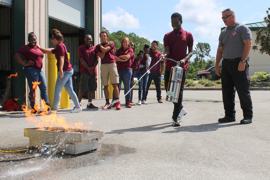 Fifteen local high school students learned about using a fire extinguisher safely during a Data Busters program demonstration. (Photo courtesy of the Flagler County Communications office.)