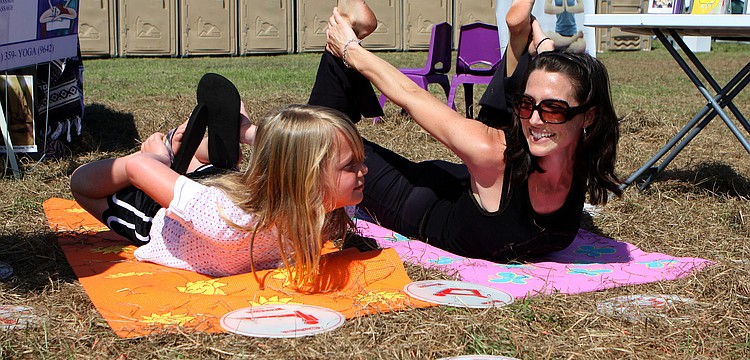 Brook Stevenson, 7, tries to copy the same yoga move as ReFlex teacher Allison Kummery on Saturday, March 19 at the Sarasota Springfest out at Palmer Ranch.