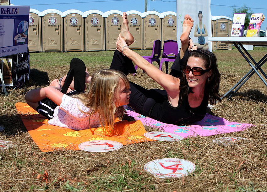 Brook Stevenson, 7, tries to copy the same yoga move as ReFlex teacher Allison Kummery on Saturday, March 19 at the Sarasota Springfest out at Palmer Ranch.