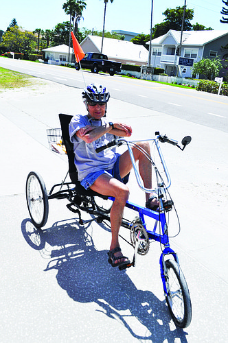 Tricycle rider Freda Perrotta follows all the rules of the road, such as wearing a helmet, when she cruises down Gulf of Mexico Drive.