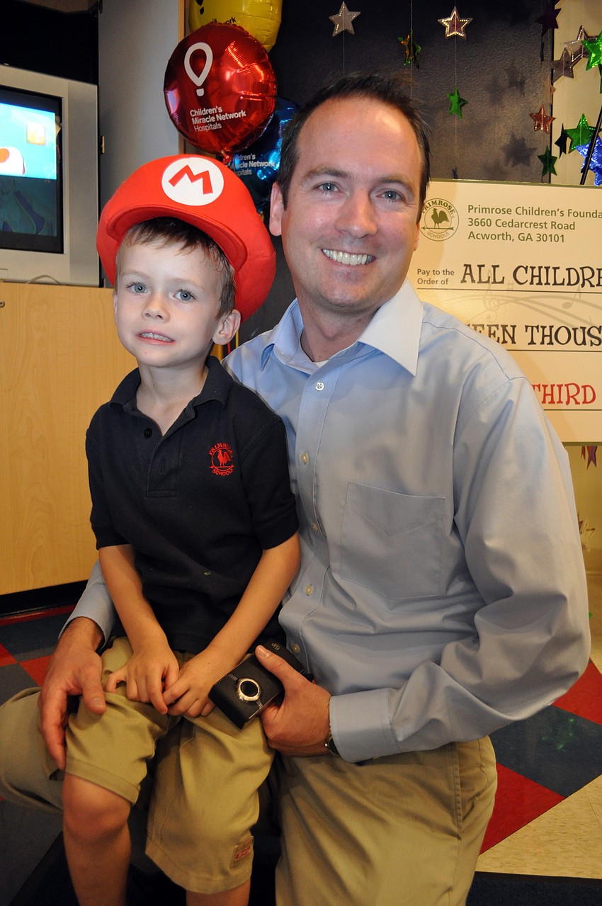 Cameron Phayre, pictured with his father Scott, said he wants to buy a swing set with his $1,500 check.