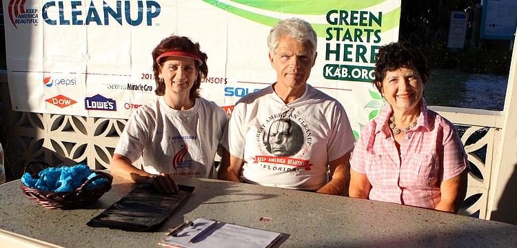 Candi and Jack Messerschmidt with Rachele Farnum worked to sign people up and hand them trash bags and blue gloves on Saturday, April 2, on Siesta Key Beach during the 2011 Great American Cleanup, part of Keep Sarasota County Beautiful.