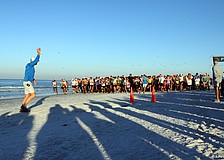Dan Pollock sounds off the air horn to signal the beginning of the 5K on Saturday, April 2 during the 25th Annual Run for the Turtles on Siesta Key Beach.