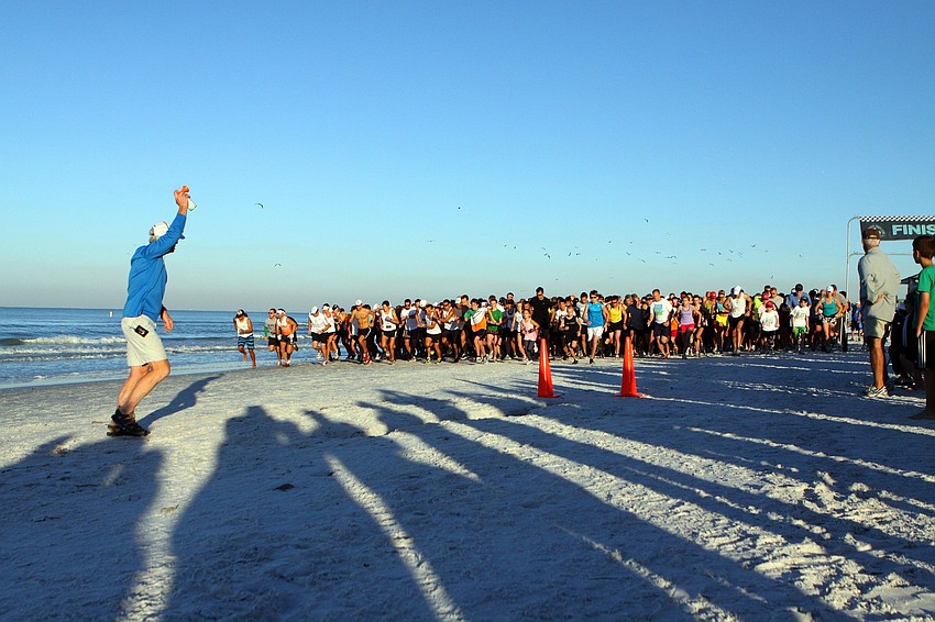 Dan Pollock sounds off the air horn to signal the beginning of the 5K on Saturday, April 2 during the 25th Annual Run for the Turtles on Siesta Key Beach.