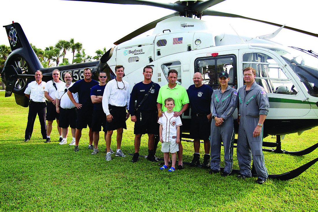 Steve Schwalbach and his son, Cameron, middle, meet March 31 with the firefighters and Bayflite flight-crew members who rescued Schwalbach.