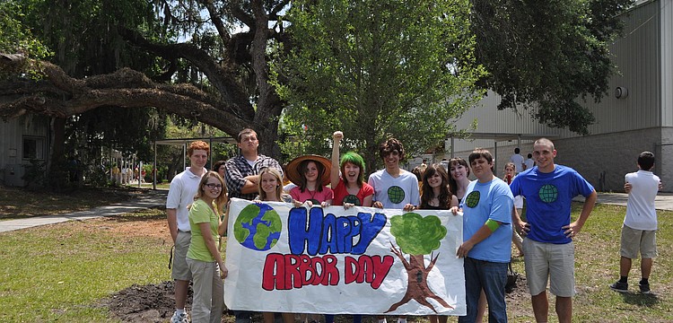 Cardinal Mooney students hold a banner they created for their Arbor Day celebration.