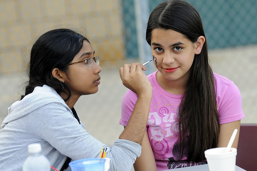 Eighth-grader Naidya Rupan painted a butterfly on sixth-grader Kaylee Burke's face.