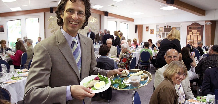 Rabbi Glickman holds up the sacred Seder plate and gefilte fish plate that are tradtionally served during Passover.