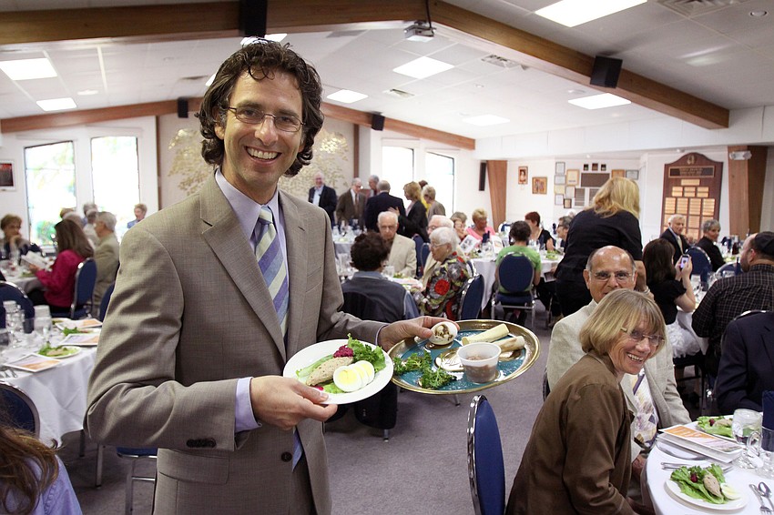 Rabbi Glickman holds up the sacred Seder plate and gefilte fish plate that are tradtionally served during Passover.