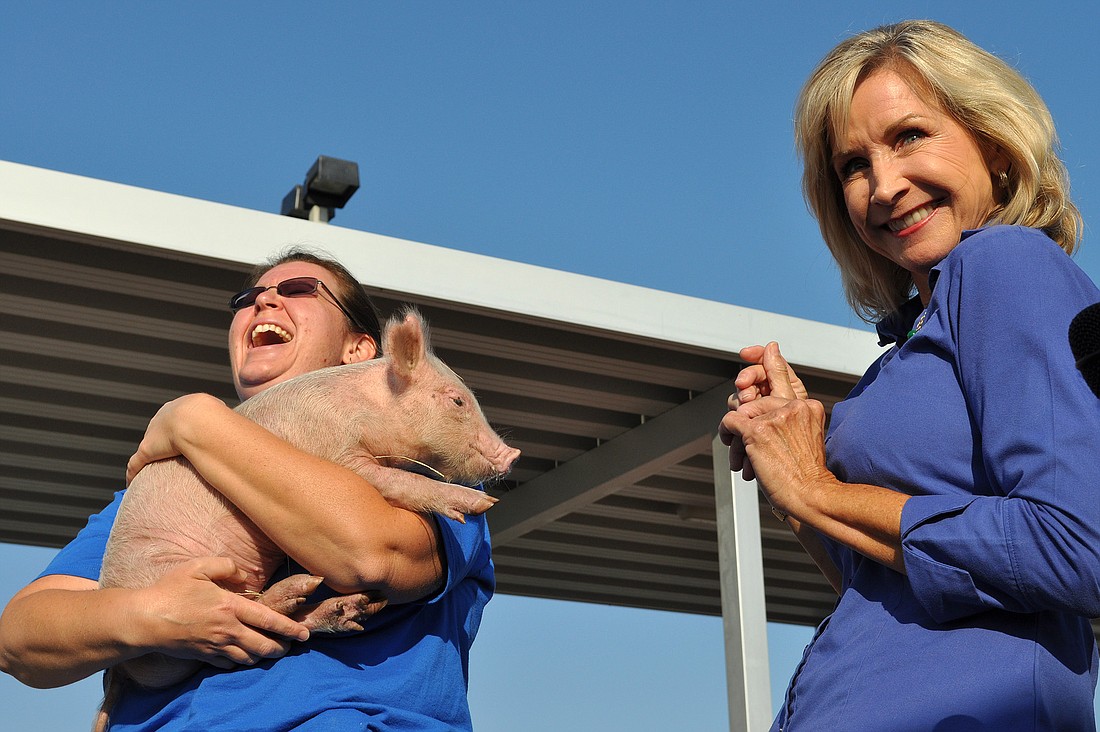 Students cheered as Principal Kathy Hayes kissed a pig.