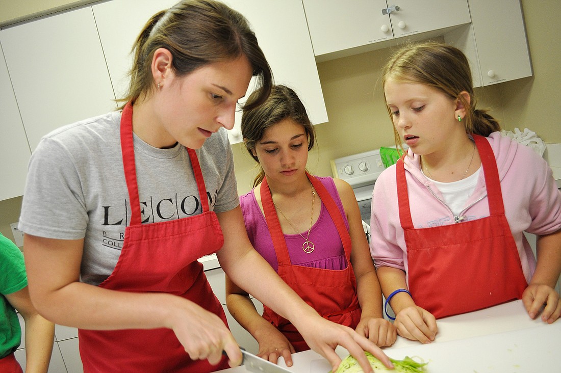  Rachel Pamplin helps Anastia Barone and Emma Wilbur cut cabbage.