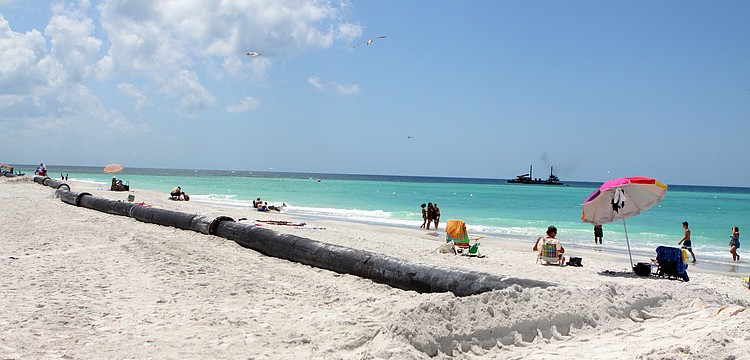 Beachgoers worked around the sand project pipeline in order to bask in the sun Monday, April 25. The pipeline is part of the emergency sand project on the north end of Longboat Key.