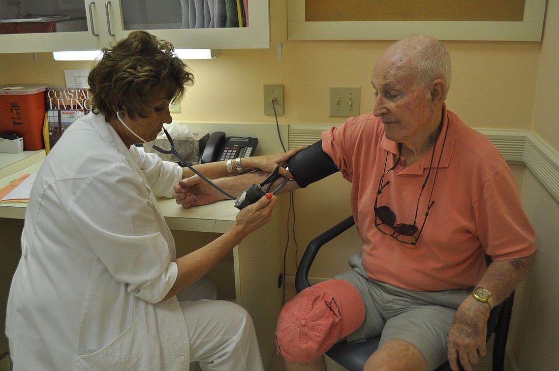 Nursing coordinator Debby Hahn examines John Kaiser at the Boca Grande Health Clinic, a facility subsidized through a nonprofit foundation. The clinic's model has been suggested for Longboat Key.