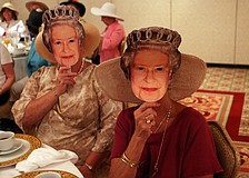 Angela Ward and Holly Kraft wear Queen Elizabeth cardboard masks Friday, April 29 while celebrating the royal wedding at the Ritz Carlton.