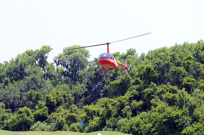 A helicopter circling overhead dropped 200 golf balls onto the practice green below.