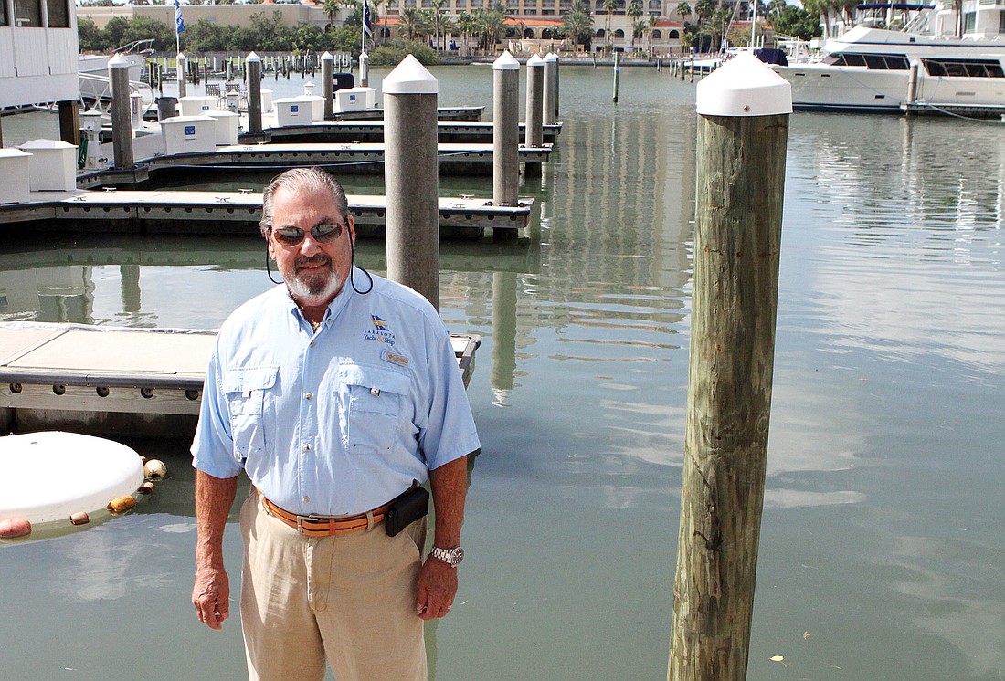 Yacht broker Roy Kaplan stands in front of the boat slips at the Hyatt Regency.