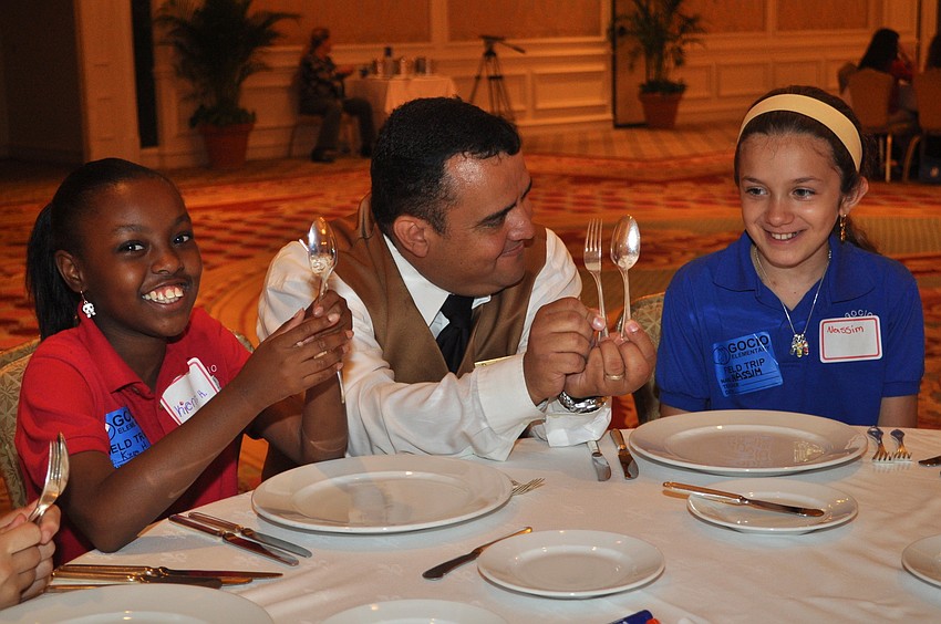 Daniel Valderrama gives Kierra Henderson and Nassim Ghaffari a lesson on proper utensil placement.