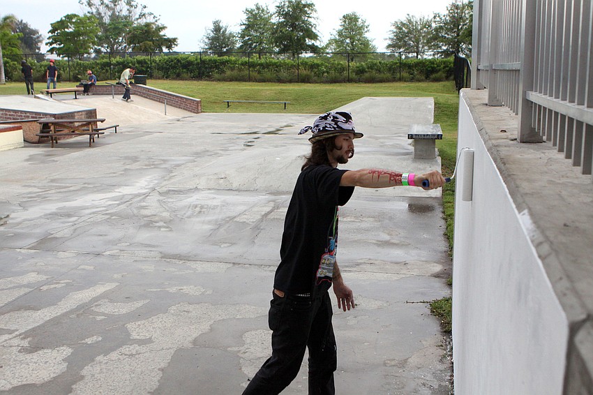 Jacob Hill of Consolidated Consciousness primes the wall that will be covered in graffiti art by Tion Bukue during the Golden Era Tour event at Payne Park's skate park.