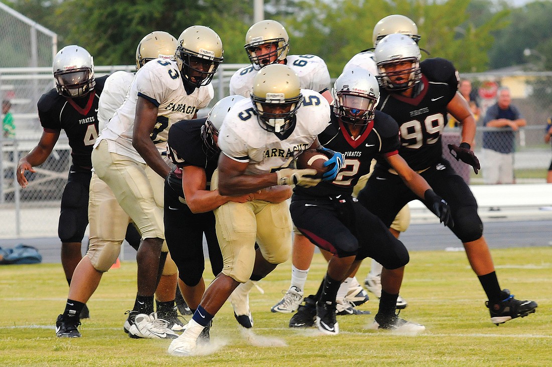 A host of Braden River defenders bring down Admiral Farragut running back Cortavous Givens during the Pirates Spring Game May 13.