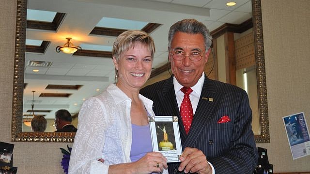 Christy Perry, of Destination Florida, receives an award from St. Armands Circle Association President Andrew Vac.